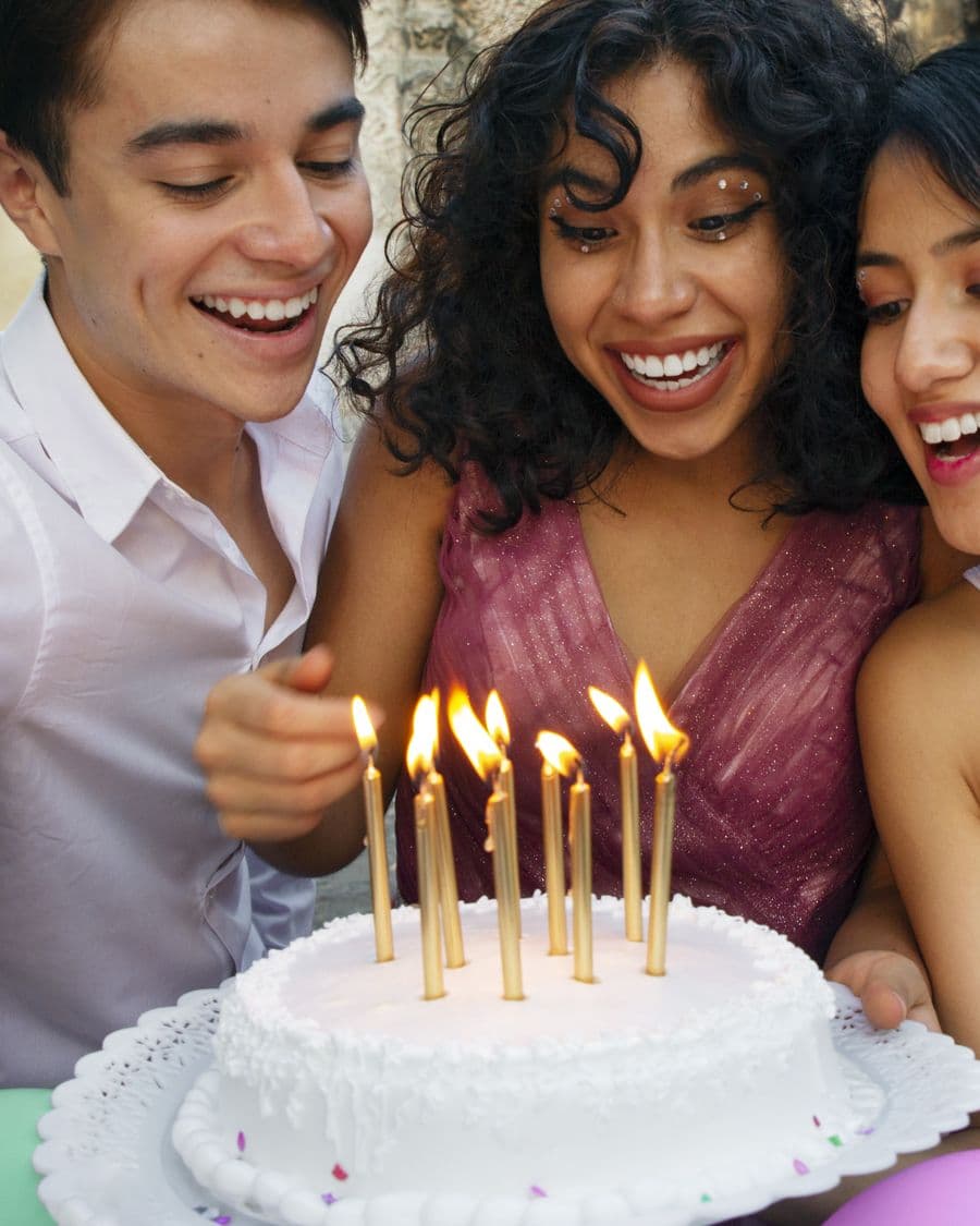 Friends cheering as a birthday cake arrives