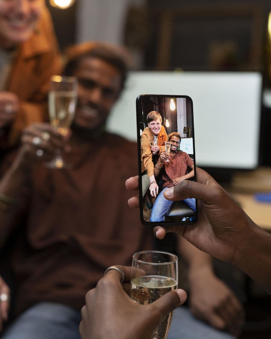Colleagues toasting while a Social Agent films them on a phone