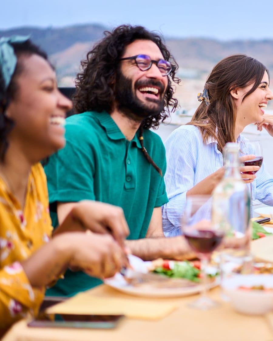 Friends laughing around a dinner table
