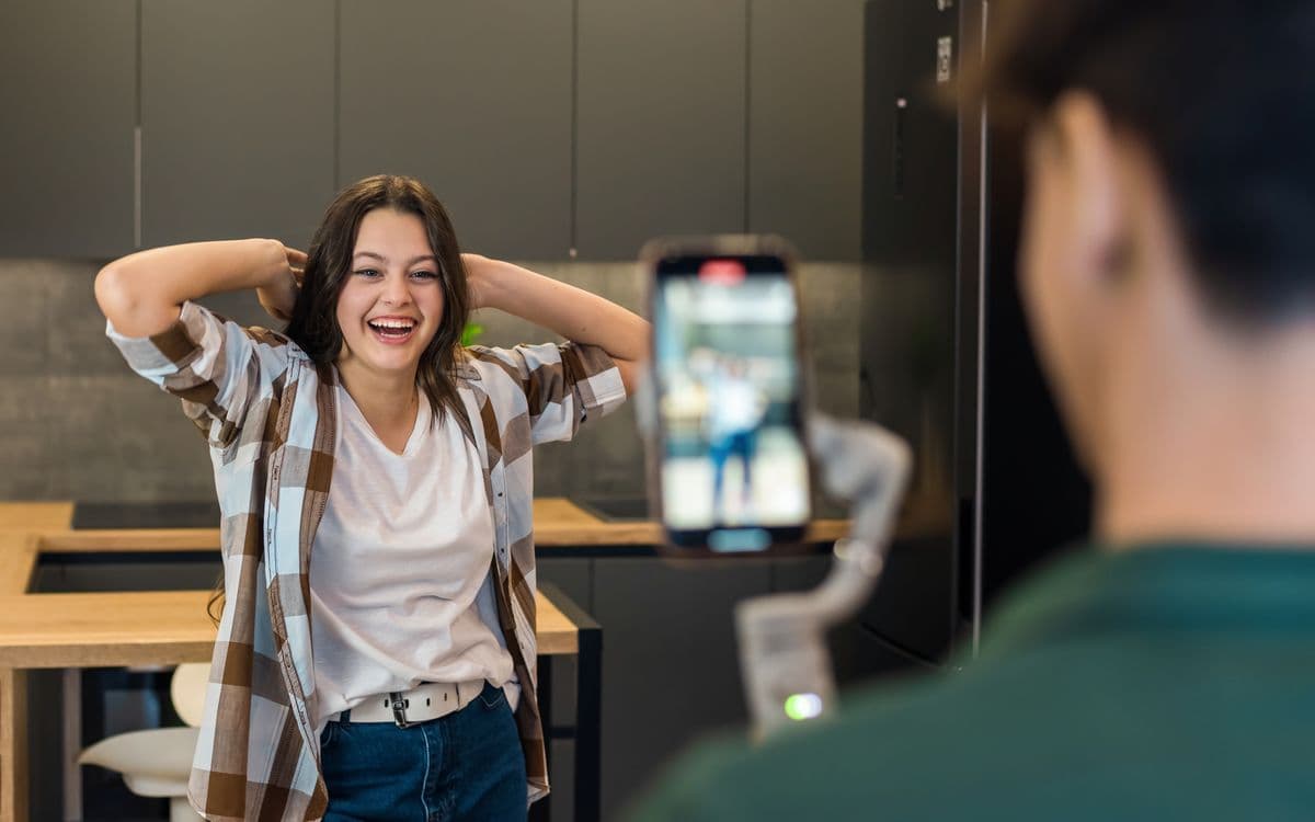 A Social Agent filming a laughing woman on a phone held upright on a gimbal